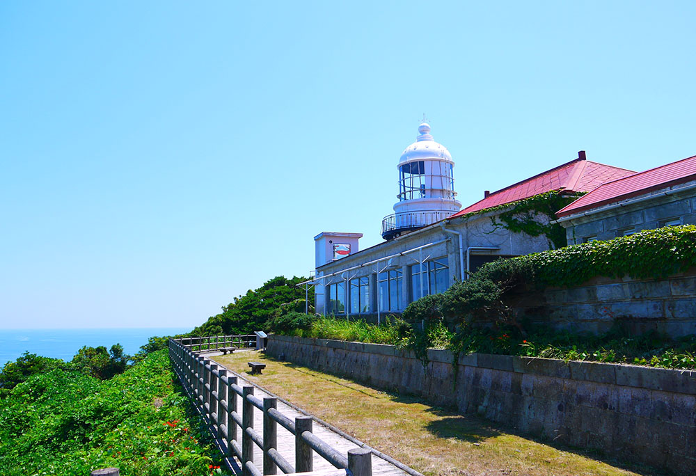 みほのせき灯台と海の拡大写真。海抜73メートル付近にあるみほのせき灯台は、1898年に建てられた石造りの灯台です。灯台のある岬からはだいせんや日本海の彼方に浮かぶ隠岐諸島などを一望することが出来ます。隣接する旧事務所や宿舎はカフェに改装され、日本海の景色を眺めながら食事をすることができます。
